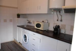 ラゴスにあるMagnoliamar 304の洗濯機と電子レンジ付きのキッチン
