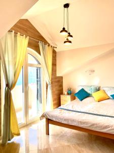 een slaapkamer met een bed en een groot raam bij Apartments G. Jovanovic in Kotor
