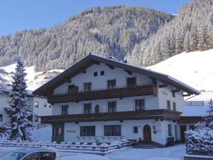ein Haus im Schnee mit einem Berg in der Unterkunft Ferienwohnungen Hinteranger in Tux