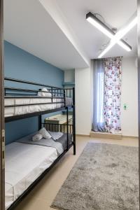 a bedroom with bunk beds and a ceiling fan at Gouves Beach Boutique Apartment in Gouves