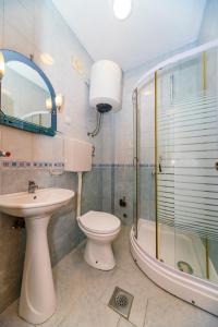 a bathroom with a toilet and a sink and a shower at Apartments Aura in Utjeha