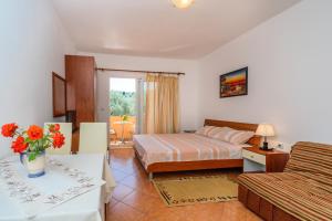 Habitación de hotel con cama y sofá en Apartments Aura, en Utjeha