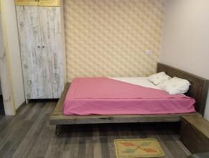 Dormitorio pequeño con cama con manta rosa en Квартира в центре Гомеля, en Gomel