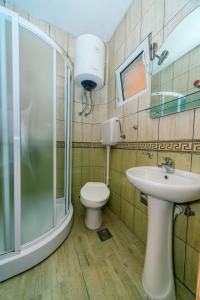 a bathroom with a shower and a toilet and a sink at Apartments Aura in Utjeha