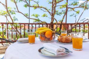 a table with a bowl of fruit and glasses of orange juice at Apartment Beky in Podstrana