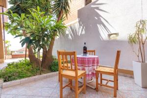 a table with a bottle of wine and two chairs at Apartment Beky in Podstrana +13 photos