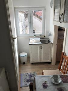 una pequeña cocina con fregadero y ventana en Apartment Ante - Diocletian's palace, en Split