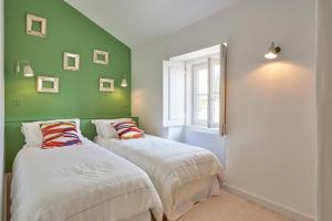 two beds in a room with green walls at Alfama Chateau - Vue Exceptionelle - Charme - Calme in Lisbon