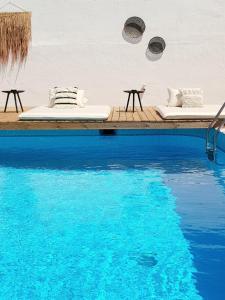 a pool with two beds next to the water at Mira Living Concept Suites Adults Only in Kokkini Khanion