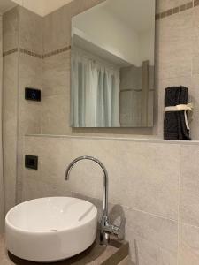 a bathroom with a white sink and a mirror at Alloggio Casa Talvena Longarone in Longarone