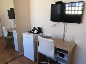 a room with a desk and a television on the wall at 5 on Jameson Guesthouse in Quigney