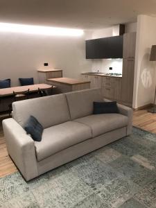un soggiorno con divano e una cucina di Alloggio Casa Talvena XL a Longarone