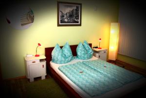 Schlafzimmer mit einem Bett mit blauer Bettwäsche und Kissen in der Unterkunft Apartment Heidi in Oberasbach