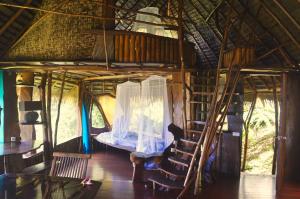 Zimmer mit Etagenbett und Leiter in einem Haus in der Unterkunft Vanira Lodge in Teahupoo