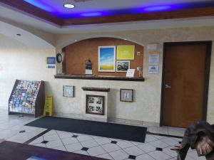 a waiting room with a door and a fireplace at Days Inn & Suites by Wyndham Cleburne TX in Cleburne