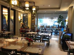 um restaurante com mesas e cadeiras e uma grande janela em Hotel Lorenza em Tacloban