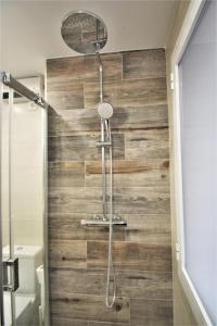 W łazience z drewnianą ścianą znajduje się prysznic. w obiekcie FH ALTEA CENTRO PLAYA w Altei