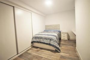 małą sypialnię z łóżkiem i drewnianą podłogą w obiekcie FH ALTEA CENTRO PLAYA w Altei