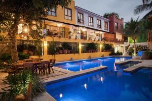 una piscina di fronte a un edificio con ristorante di Casa Lotería -Pueblito Sayulita- Colorful, Family and Relax Experience with Private Parking and Pool a Sayulita