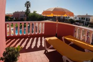 a balcony with two chairs and an umbrella at Solar de Mos in Lagos