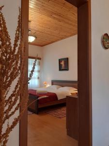 1 dormitorio con cama y techo de madera en Grandpa’s Home, en Gjirokastra