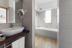 a white bathroom with a sink and a bath tub at Solar de Mos in Lagos