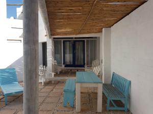 - une table et des chaises sur la terrasse couverte d'une maison dans l'établissement Mosselbank Beach Retreat 2, à Paternoster