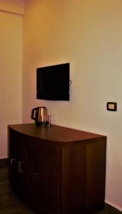 a room with a tv on the wall and a wooden cabinet at New MerryLand Hotel in Amman