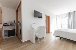 a bedroom with a bed and a desk and a tv at Solar de Mos in Lagos