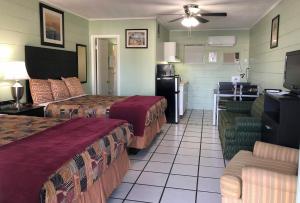 a hotel room with two beds and a kitchen at Sunshine Inn & Suites Venice, Florida in Venice