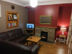sala de estar con sofá y chimenea en Helens Self Catering, en Castlebar