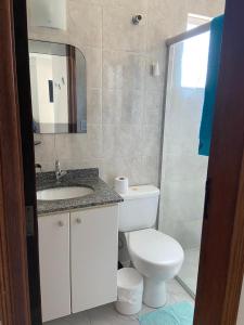 uma casa de banho com um WC, um lavatório e um espelho. em APTO CAIOBÁ em Caiobá