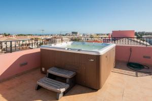 a hot tub on a balcony with two stools at Solar de Mos in Lagos