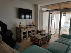 - un salon avec un canapé et une télévision dans l'établissement Mosselbank Beach Retreat 2, à Paternoster