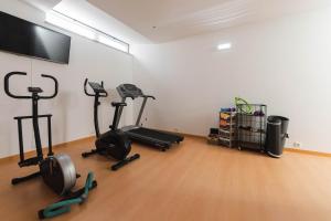 a gym with exercise bikes and a flat screen tv at Solar de Mos in Lagos