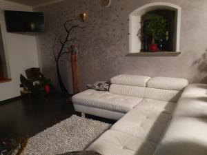 a living room with a white couch and a guitar at Villa La Tour in Nus