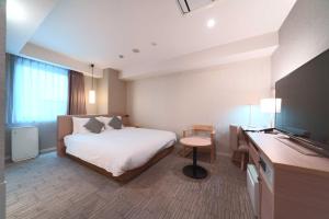 a hotel room with a bed and a television at Meitetsu Inn Hamamatsucho in Tokyo
