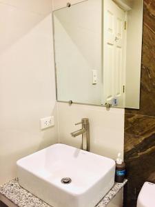 a bathroom with a white sink and a mirror at MAISON HOTEL in Cauayan City