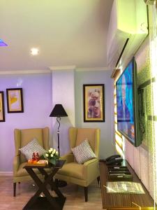 sala de estar con 2 sillas y TV de pantalla plana en MAISON HOTEL en Ciudad de Cauayán
