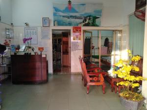una tienda con mesa, sillas y flores amarillas en Hai Hien Guesthouse, en Phu Quoc