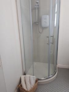 a bathroom with a shower with a basket of towels at Ballycastle Town Centre Apartment in Ballycastle