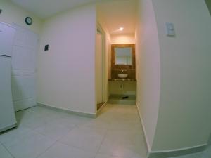 La salle de bains est pourvue d'un lavabo et d'un mur blanc. dans l'établissement NUNA, à San Salvador de Jujuy