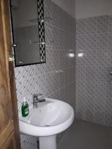 a bathroom with a white sink and a mirror at Hotelgandiol - Saint-Louis in Saint-Louis