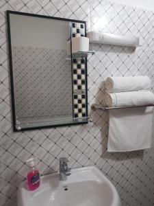 y baño con lavabo, espejo y toallas. en Hotelgandiol - Saint-Louis en Saint-Louis
