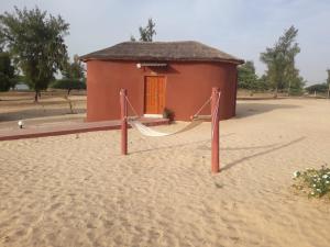 a small building with a hammock in the sand at Hotelgandiol - Saint-Louis in Saint-Louis