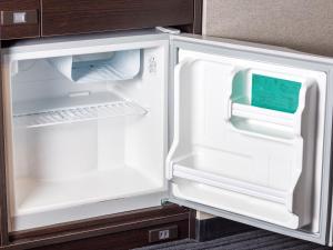 an empty refrigerator with its door open in a kitchen at APA Hotel Shin Osaka Ekimae in Osaka