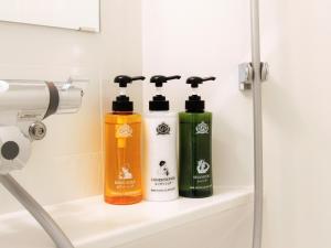 two bottles ofodorizers sit on a shelf in a bathroom at APA Hotel Shin Osaka Ekimae in Osaka