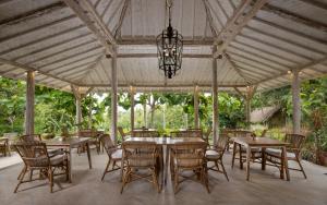 a patio with tables and chairs and a chandelier at The Mesare Eco Resort in Nusa Penida