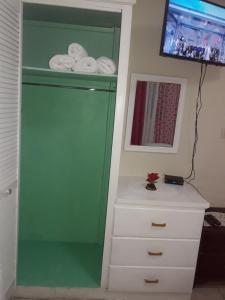 a green cabinet next to a white dresser with towels at Hilltop View Guesthouse in Castries