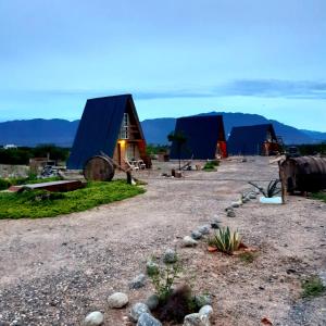 Cabañas "Los Elementos", San Carlos, Salta, في سان كارلوس: مجموعة من الأكواخ مع جبال في الخلف